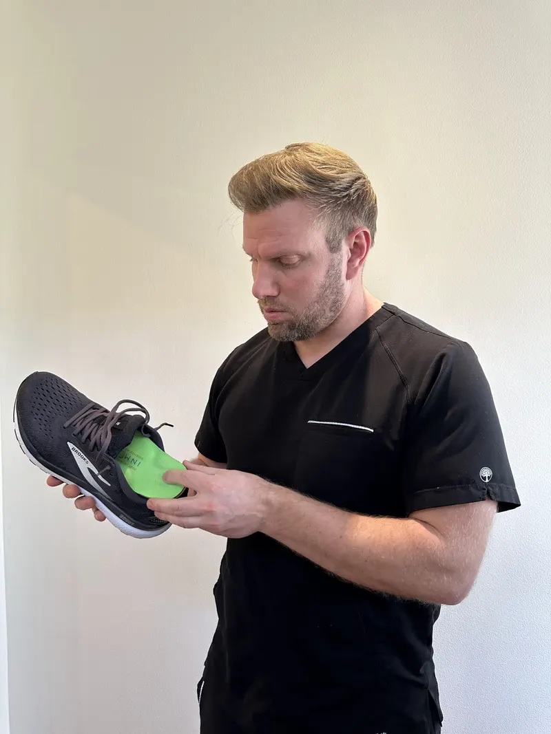 Dr. Jason fitting a custom orthotic into a running shoe